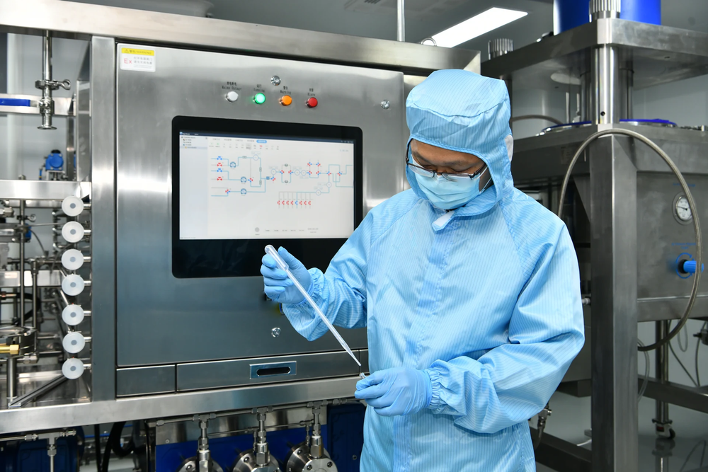 Operator handling a sample beside a process console
